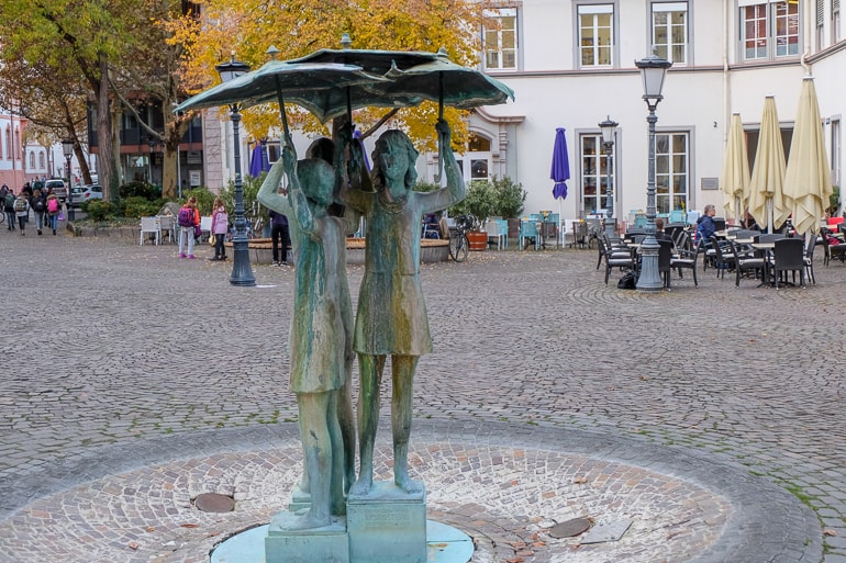 metal fountain of girls with umbrellas in square things to do in mainz germany