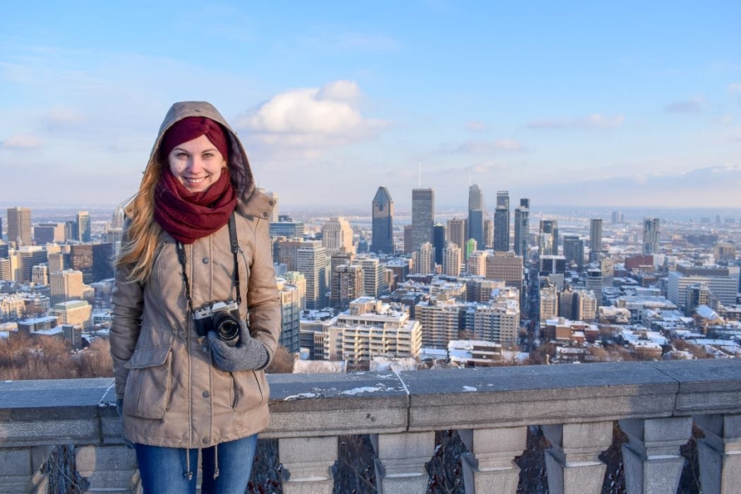 girl in winter coat with city behind canada packing list