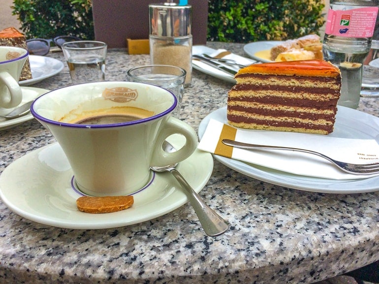 coffee in mug with slice of cake on table one day in budapest