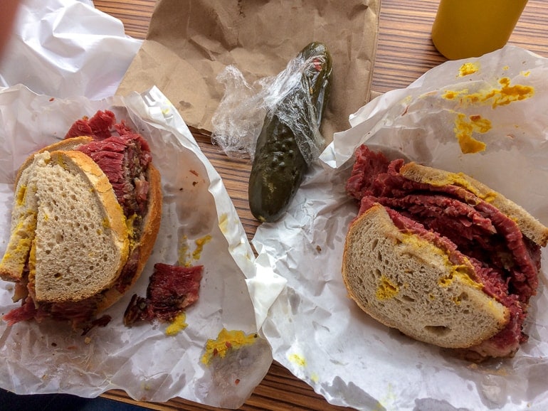 Sandwich mit geräuchertem Fleisch und Gurke auf Tisch Schwartz Deli Montreal