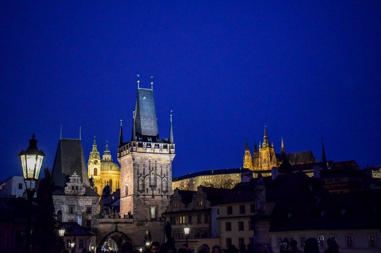 Beleuchtete Prager Burg bei Nacht mit Karlsbrücke