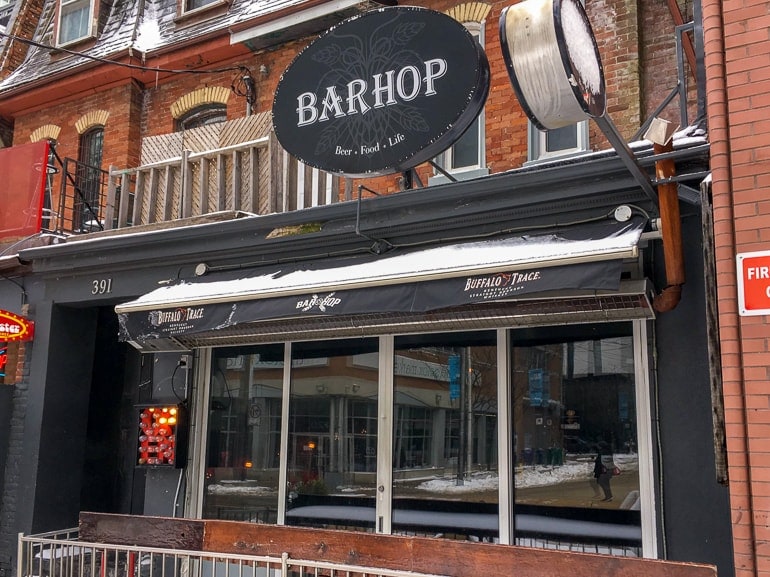 bar sign and front patio from sidewalk one day in toronto
