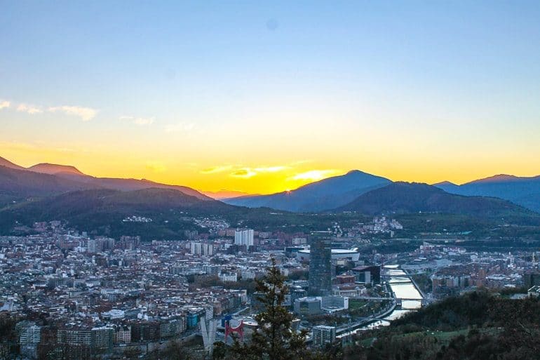 Stadt mit Fluss und Sonnenuntergang über den Bergen Sehenswürdigkeiten Bilbao