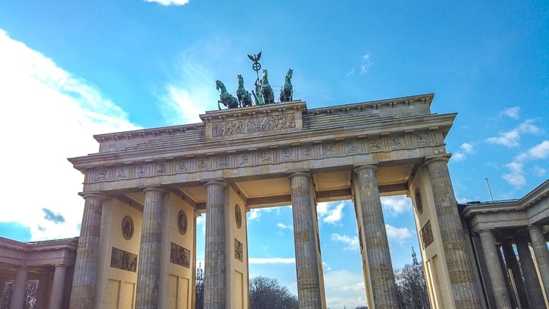 stone gate with pillars and statue on top in berlin.