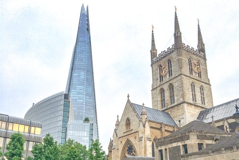 Großes Gebäude aus Glas mit alter Kirche im Vordergrund The Shard London