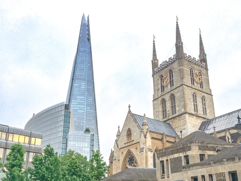 Großes Glasgebäude und alter Kirchturm London an einem Tag