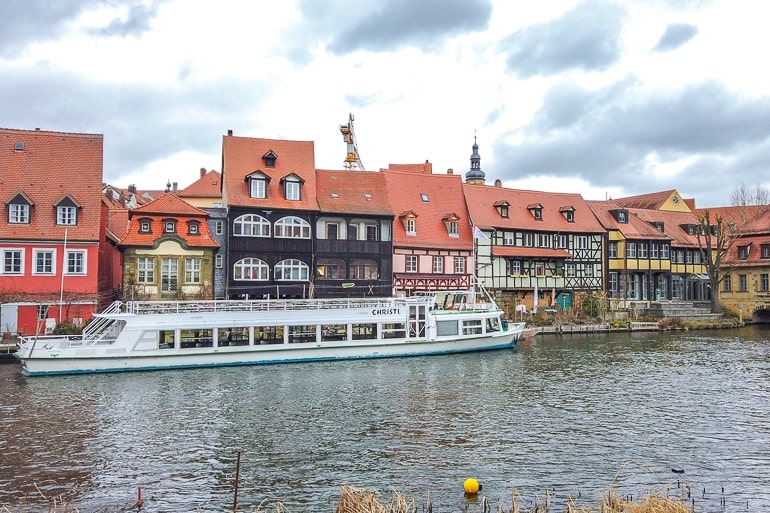 colourful houses lining river with boat in front bamberg germany