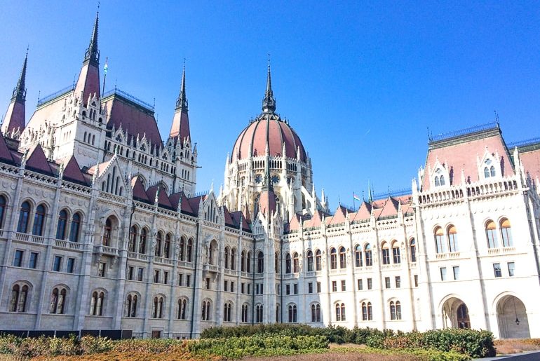 Weißes gotisches Gebäude mit roter Kuppel ungarisches Parlament Budapest