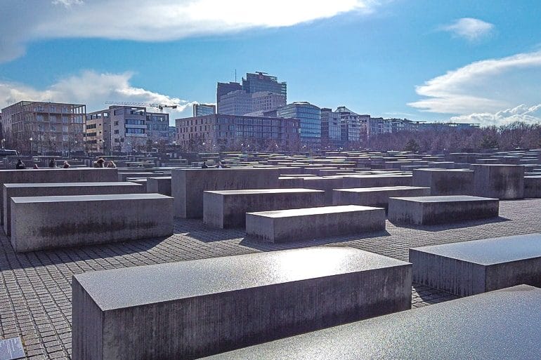 concrete blocks with blue sky behind memorial to murdered jews in berlin