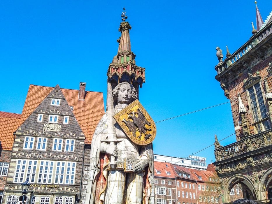 Statue aus Stein auf Marktplatz in Bremen mit blauem Himmel