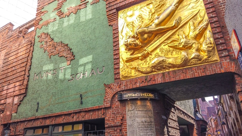 golden statue with red brick alleyway behind bottcherstrasse breman germany