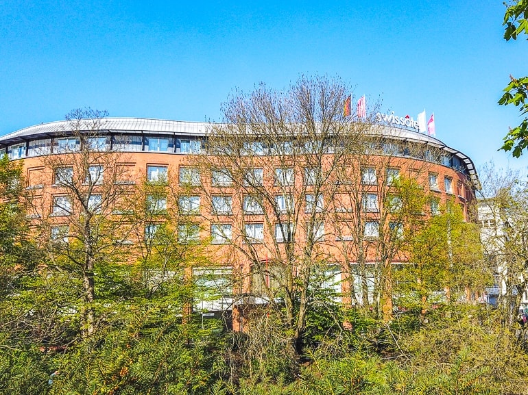 red brick hotel through trees with blue sky swisshotel bremen