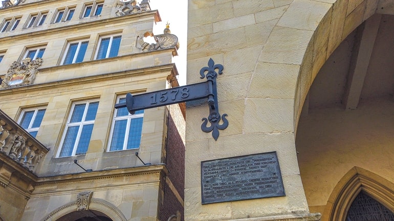 Jahreszahl auf Metallschild an Steinwand in Altstadt von Münster