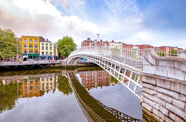 white bridge over river liffey with colourful houses on river bank