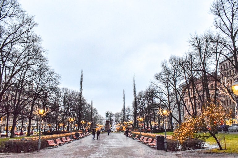 Stadtpark mit Bänken und Statue entlang des Weges Helsinki Finnland