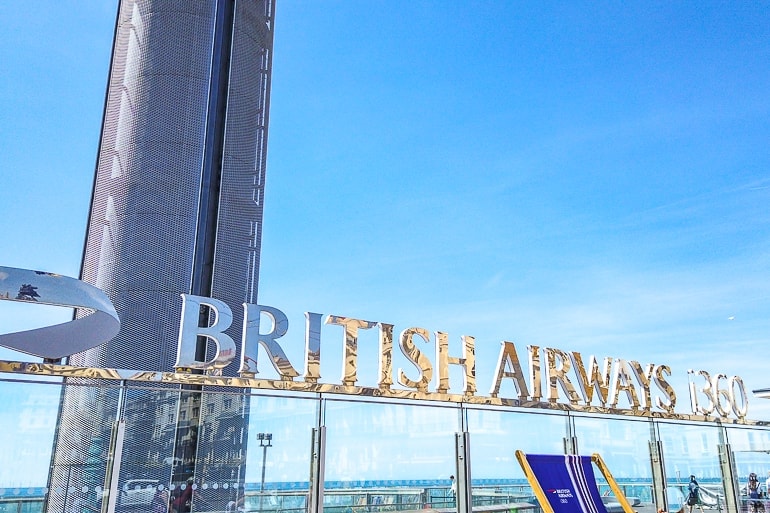 metallic british airways sign on wall with blue sky behind.