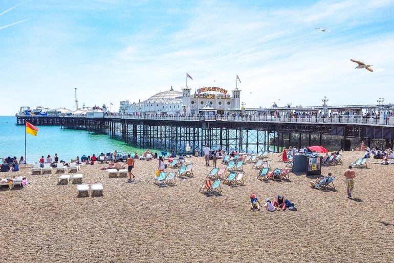 Alter Pier über Wasser mit Strand im Vordergrund Attraktionen Brighton