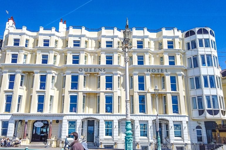 Gelbes und blaues Hotel an Küste mit blauem Himmel in Brighton England