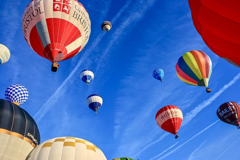 hot air balloons taking off into blue sky at bristol balloon fiesta.