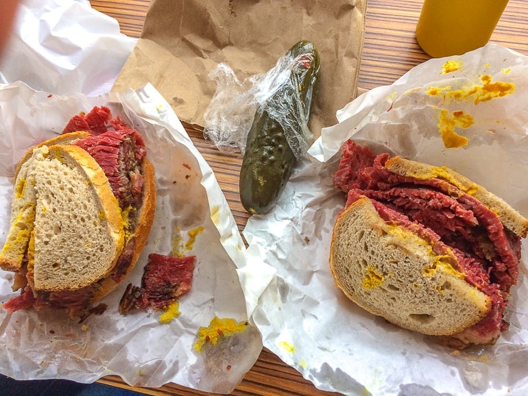 meat sandwiches on paper with green pickle between things to do in montreal