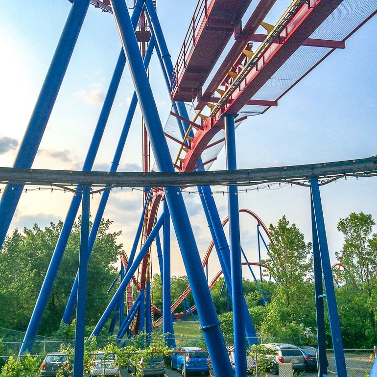 blue supports underneath a red track roller coaster at la ronde park in montreal