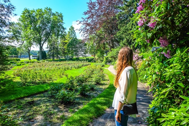 Frau erkundet grünen Garten mit Blumen in Niagara Falls