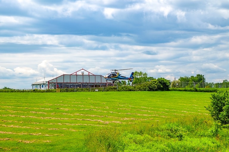 Helikopter hebt ab von grünem Landeplatz in Niagara Falls Kanada Attraktionen