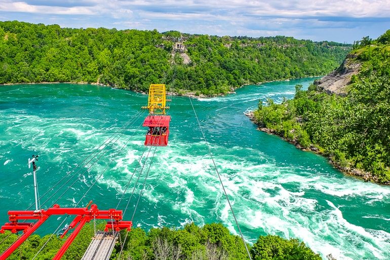 Rote Seilbahnwagen über Wasser bei Niagara River