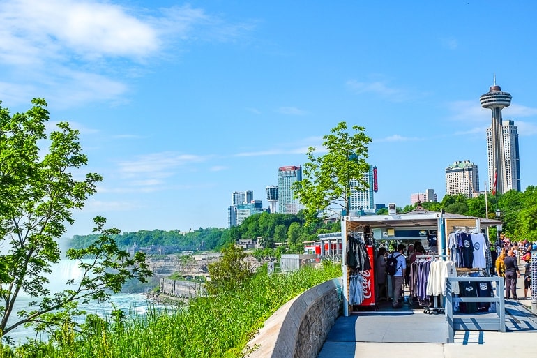 souvenir shop in front of hotels overlooking green trees of niagara river.