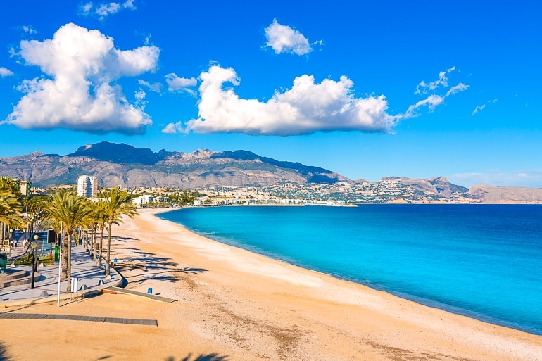 Blaues Meer mit Sandstrand und Stadt im Hintergrund Alicante Spanien