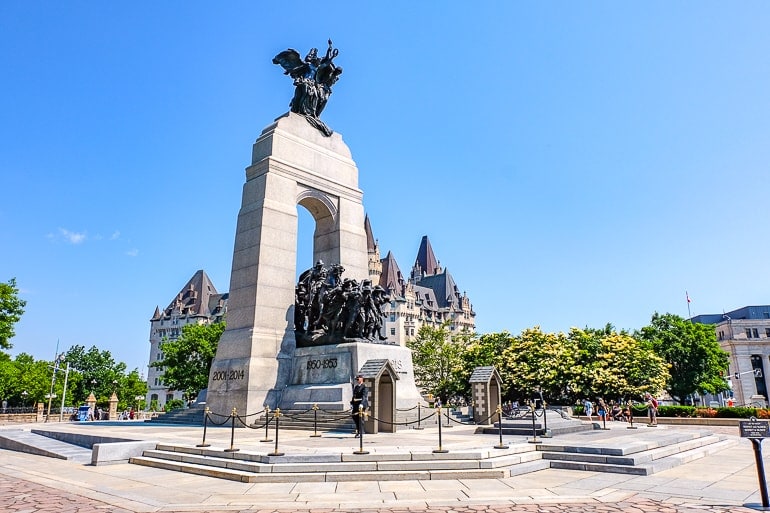 large stone arch monument with statues under in ottawa