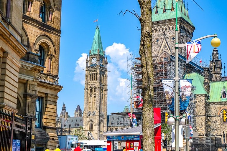 Uhrturm mit Gebäuden und Bäumen im Vordergrund Ein Tag in Ottawa