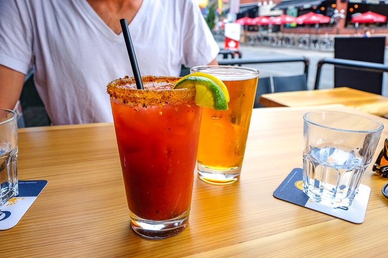 canadian caesar drink with pint of beer on wooden table one day in ottawa
