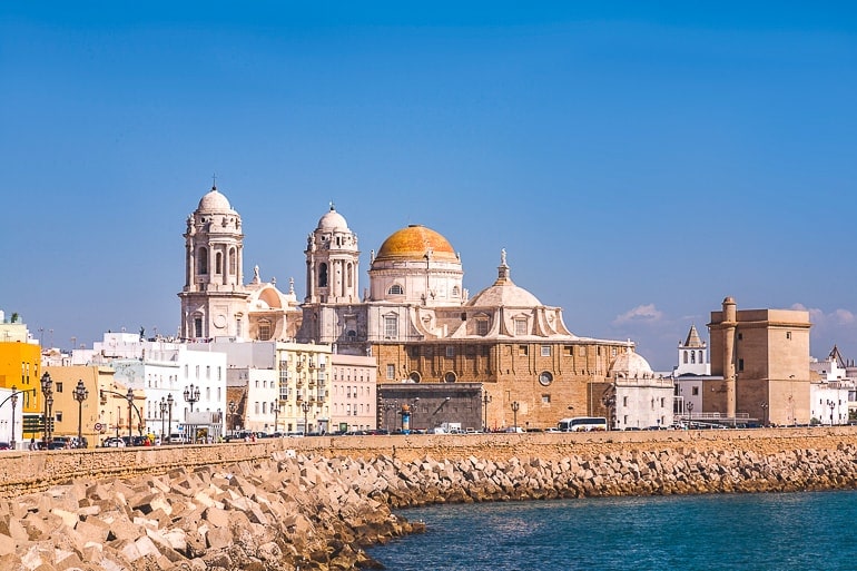 orange dome and towers of church building with shoreline beside spain itinerary