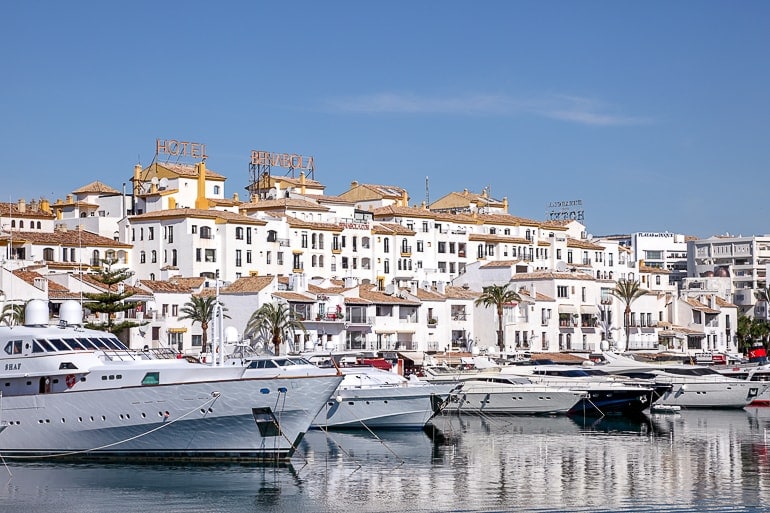 Weiße Boote an Hafen mit weißen Häusern im Hintergrund Marbella Spanien