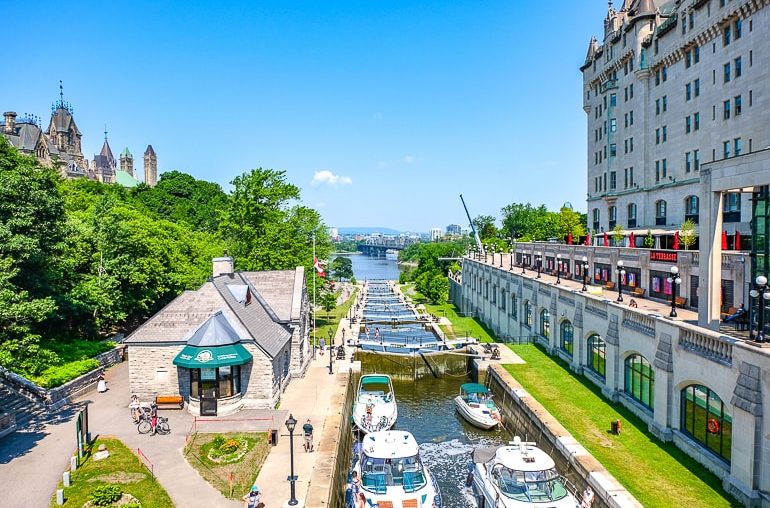 boats in locks with trees and hotel beside in ottawa rideau canal