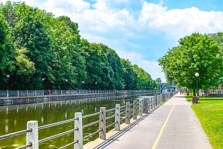 long canal with trees and sidewalk beside.