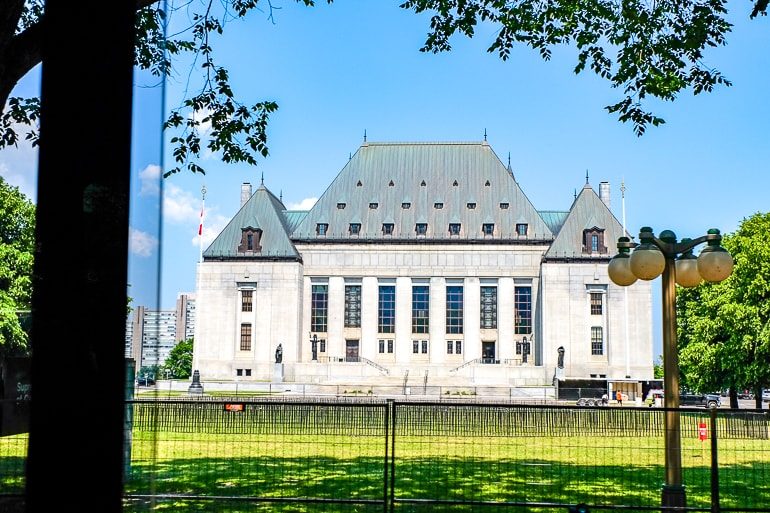 Weißes und graues Gerichtsgebäude mit grünem Gras im Vordergrund Oberster Gerichthof Kanada