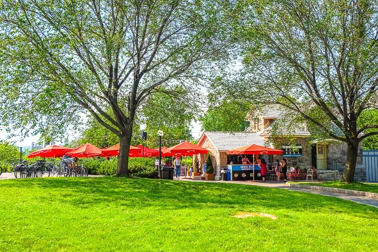 Pub mit roten Sonnenschirmen und grünem Gras im Vordergrund