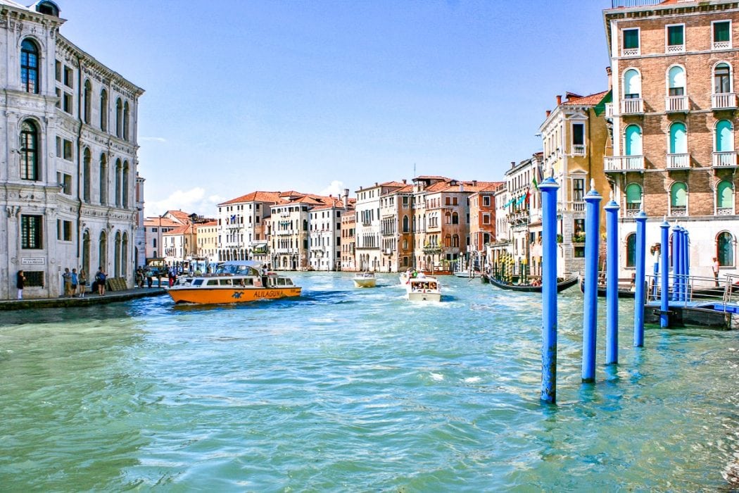 blue canal water with boats and houses beside things to do in venice italy