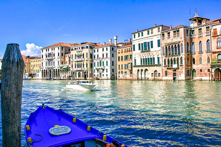 Blaues Boot mit Kanal und Häusern im Hintergrund in Venedig Italien