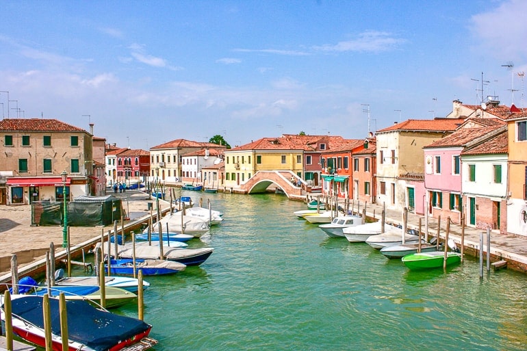 Kleine Häuser entlang des Kanals mit Booten an Anlegestellen Murano Italien