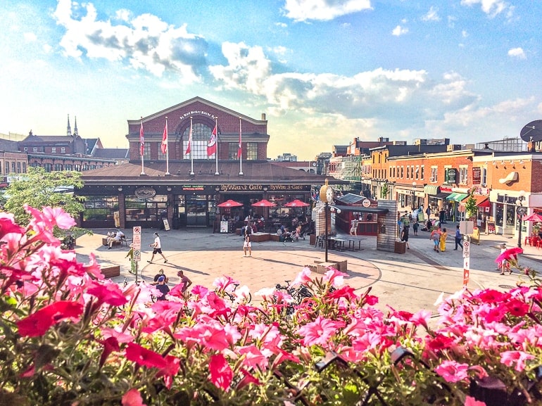 Großes rotes Marktgebäude mit Vorplatz und Blumen im Vordergrund Byward Market Ottawa