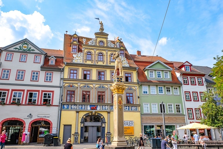 yellow old building with golden statue in front in german square erfurt germany kunsthalle