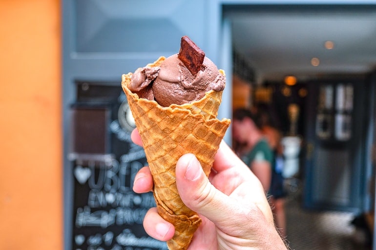 chocolate ice cream cone held in hand