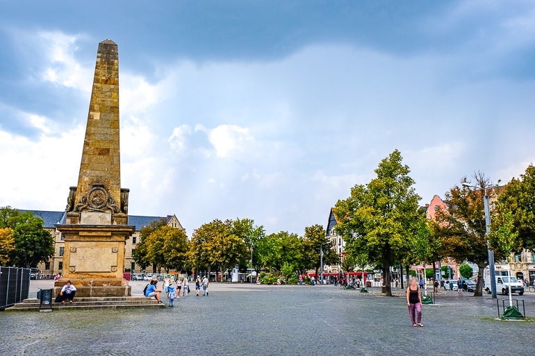 Offener Platz mit Menschen und Skulptur aus Stein auf Domplatz in Erfurt
