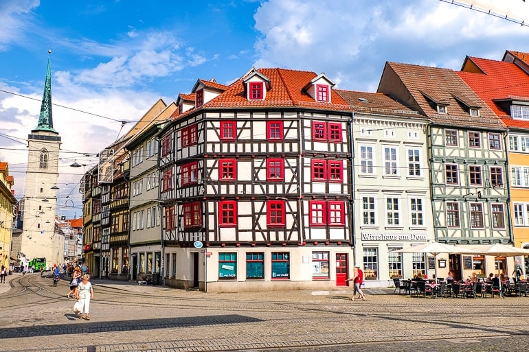 Rotes und weißes Gebäude an Straßenecke mit Straßebahn in der Nähe Erfurt Deutschland