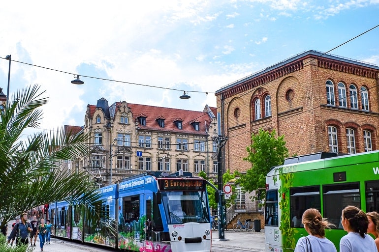 Straßenbahn fährt durch Stadt mit Gebäuden im Hintergrund
