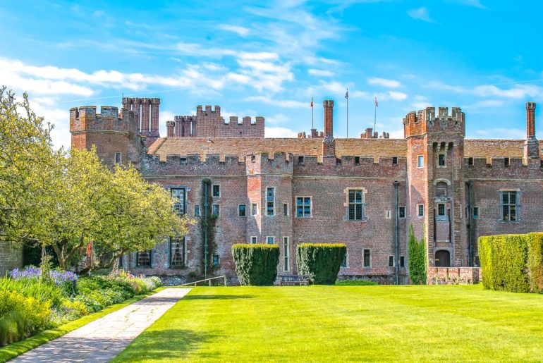 red brick herstmonceux castle with green gardens day trips from london