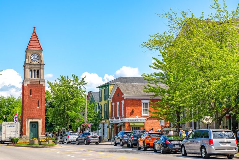 cars parked along street with red brick clock tower in road day trips from toronto niagara on the lake